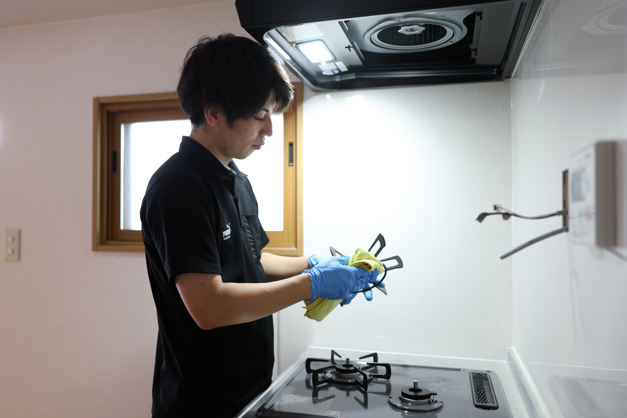 コンロを磨くスタッフ