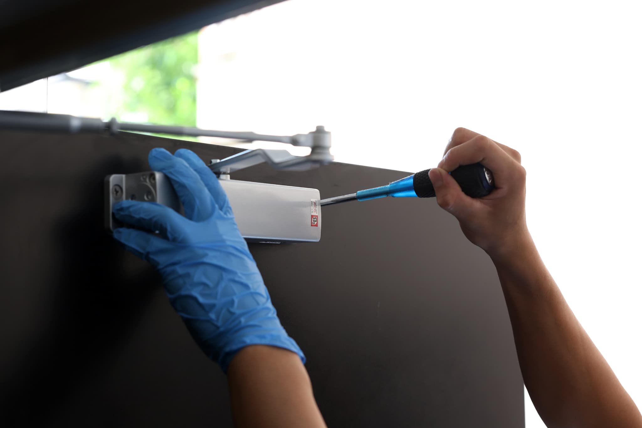 ドライバーでドアノブを外す様子