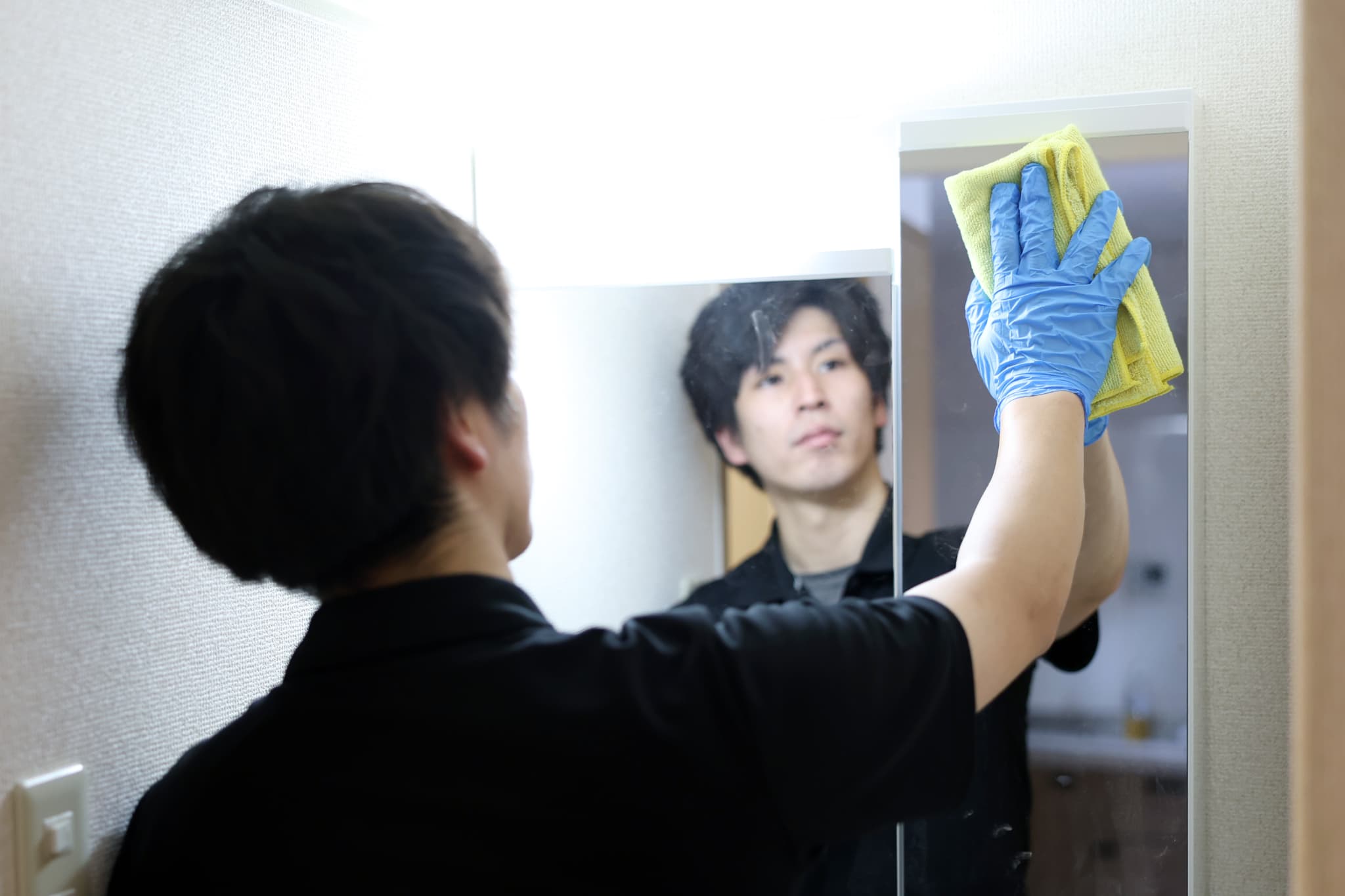 鏡を磨くスタッフ